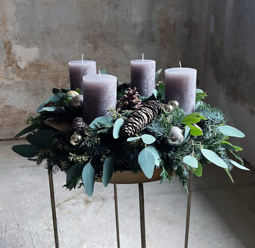 Frischer Adventkranz mit grauen, bräunlich schimmernden Kerzen.